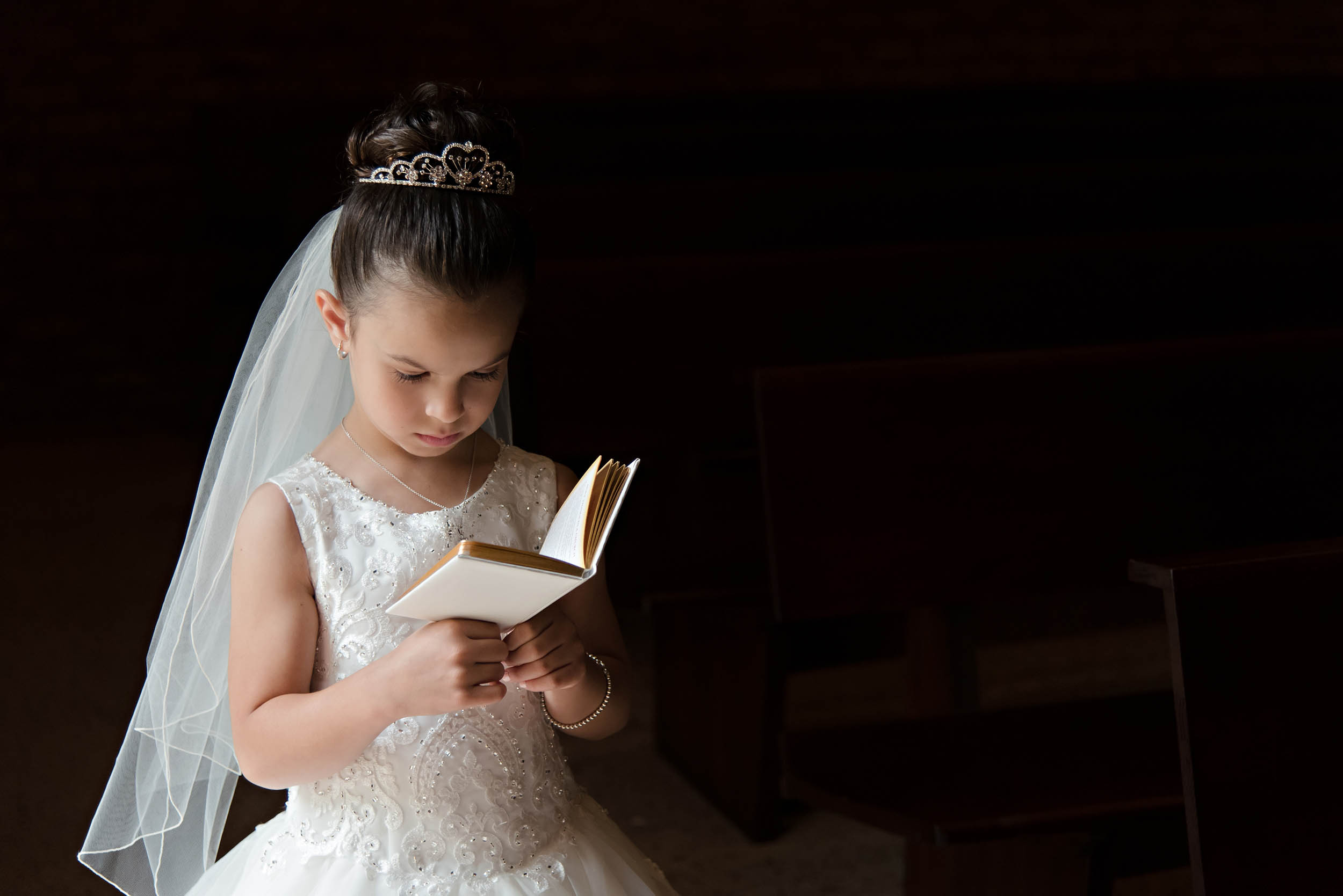 Young girl reading in preparation for first communion - Vanessa Guzzo Photography