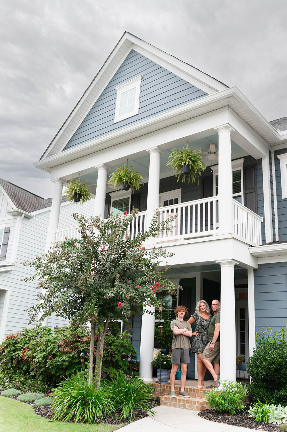 Modern family portrait of a mother, father and teenage son in front of their Charlotte NC house - photo by Vanessa Guzzo Photography